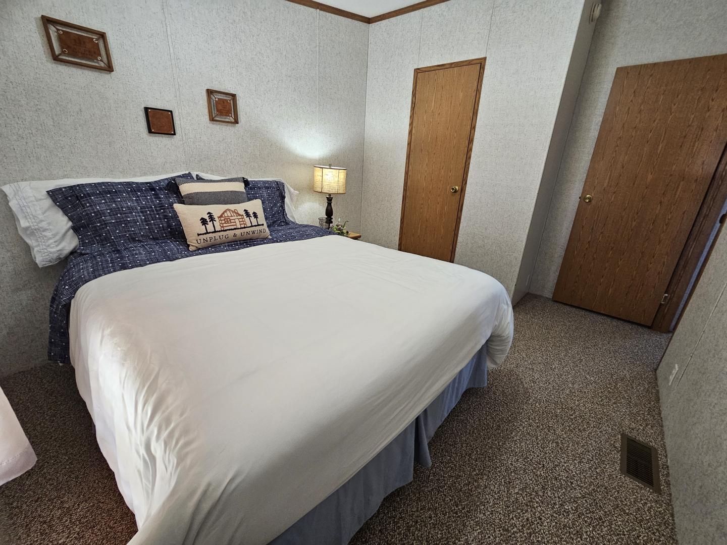 Cozy cabin bedroom with nightstand and Queen sized bed